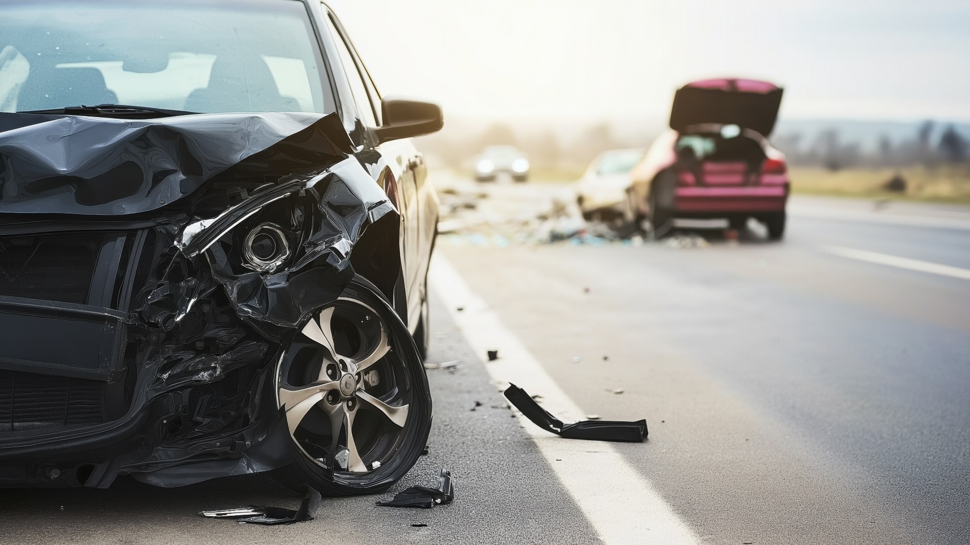 Elevated view of damaged cars on roadside after accident showing faded colors and destruction